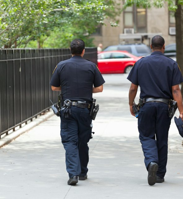 Two police officers from the back in the center of Manhattan.